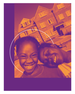 Two black children, both girls, they are smiling in front of a group of houses, one has her head on the other's shoulder.